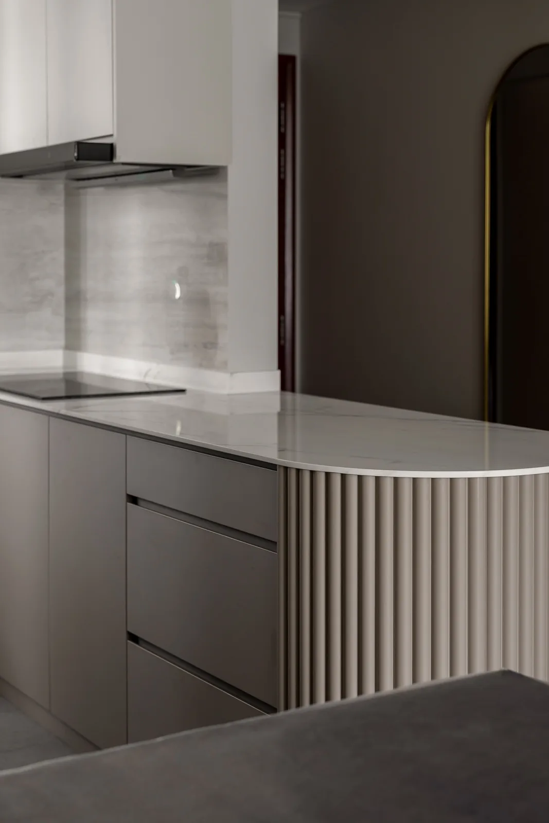 Modern kitchen island with fluted cabinetry and marble countertop