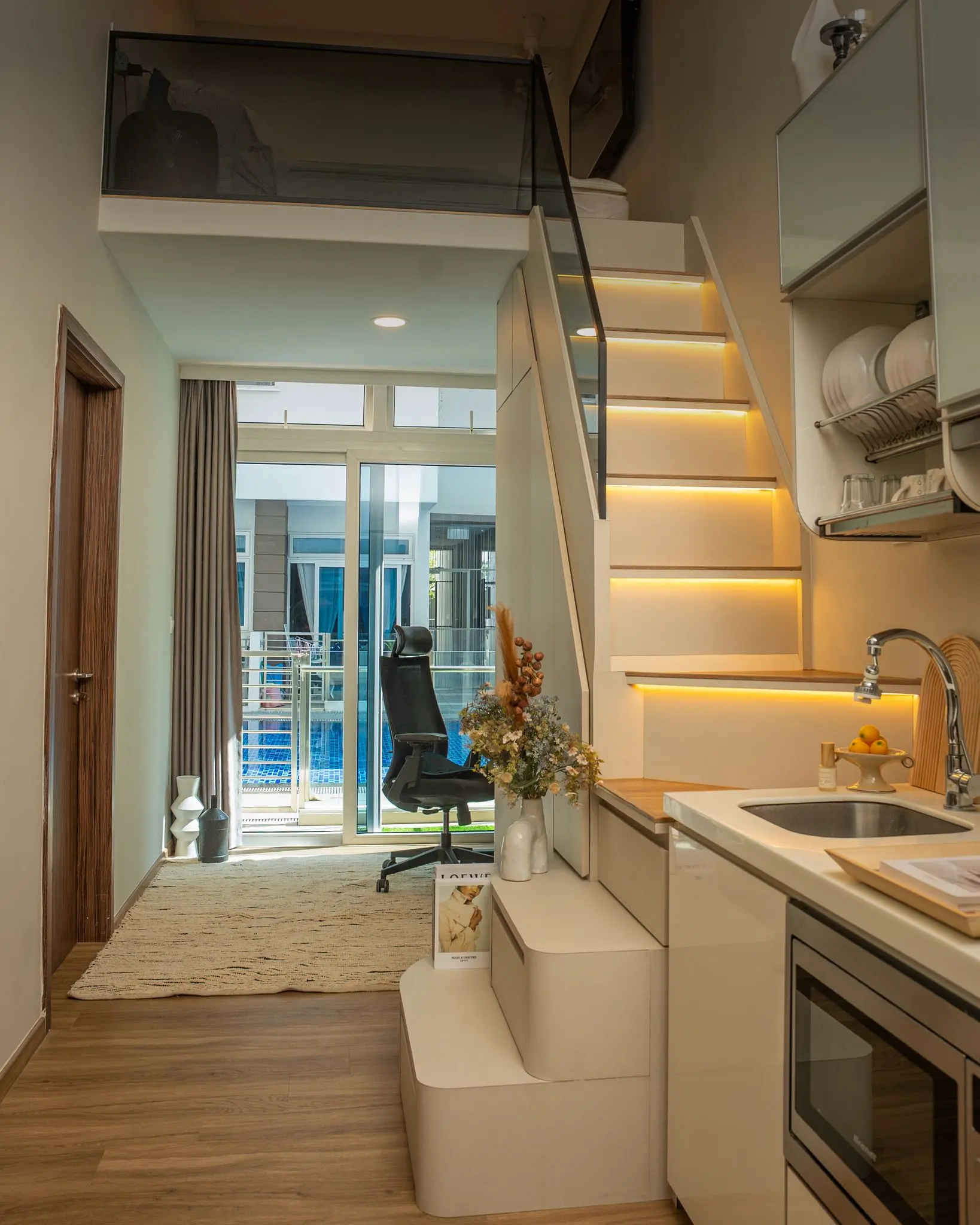 Modern loft kitchen with staircase and balcony view.